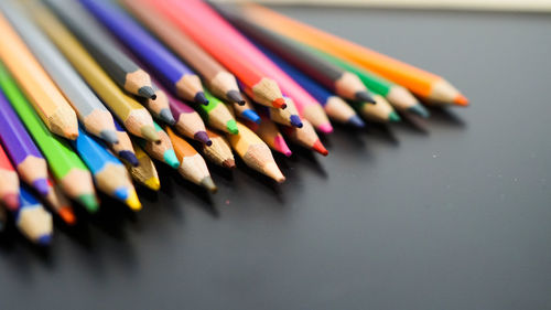 Close-up of multi colored pencils on table