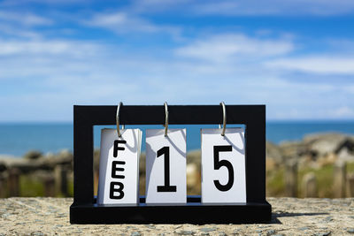 Close-up of information sign on beach