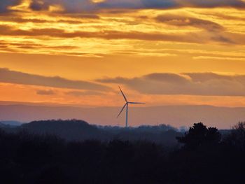 Low angle view of silhouette windmill against sky during sunset