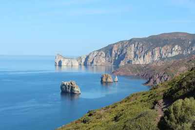 Scenic view of sea and mountains against sky