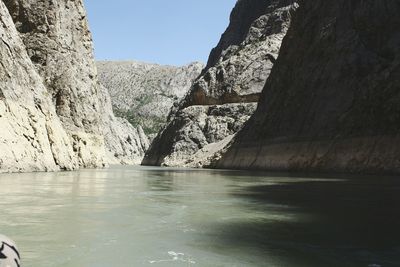 Scenic view of sea and mountains against sky at canyon 