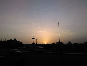 Vehicles on road at sunset