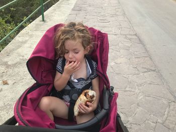 High angle view of girl sitting outdoors