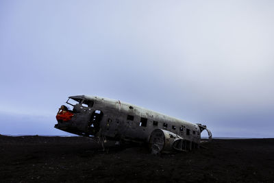 Abandoned airplane on runway against sky