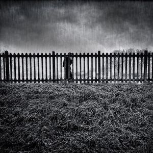Fence on beach against sky
