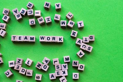 High angle view of text on wooden blocks over green background