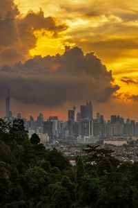 Buildings in city against sky during sunset