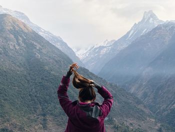 Rear view of woman in mountains against sky