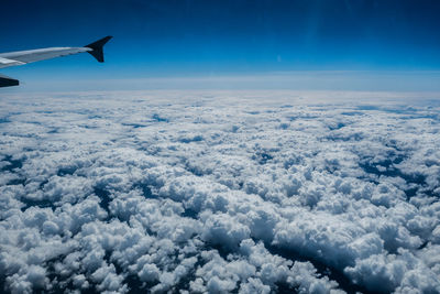 Aerial view of airplane wing over clouds