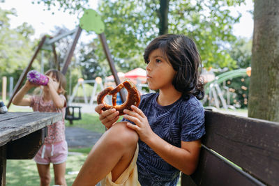 Young woman blowing bubbles while sitting at park