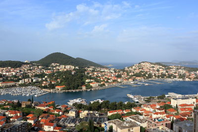 High angle view of townscape by sea against sky