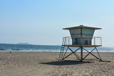 Lifeguard hut on beach against sky