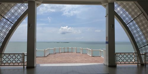 Scenic view of sea against sky seen through railing