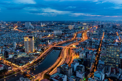 High angle view of illuminated city against sky at dusk