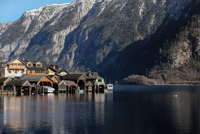Houses of hallstatt by lake and mountains against sky