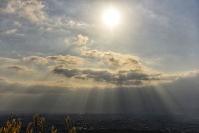 Sunlight streaming through clouds over land