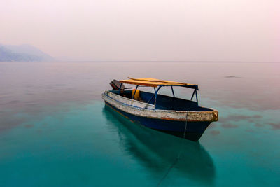 Boat moored on sea against sky