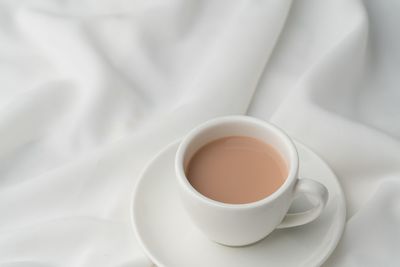 High angle view of coffee cup on bed