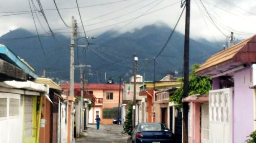 Houses by street against sky