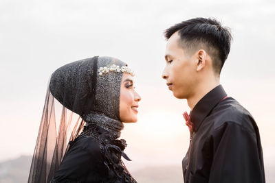 Portrait of young couple against sky