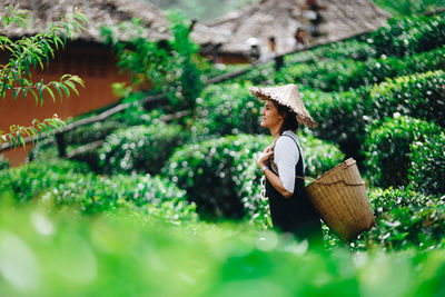 Farmer carrying wicker basket while working at farm