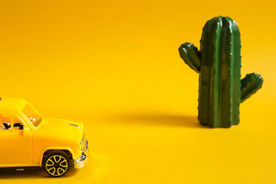 Close-up of toy car against yellow background