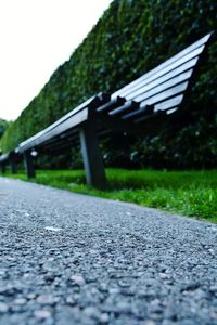 Close-up of road by trees against sky