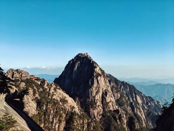 Panoramic view of rocky mountains against clear blue sky