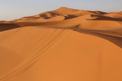 Sand dunes in desert against clear sky