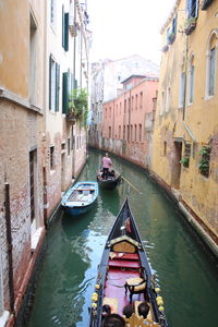 Boats in canal amidst buildings in city