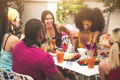 High angle view of friends enjoying lunch in yard