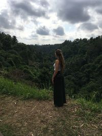 Woman standing on field against sky