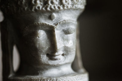 Close-up of buddha statue against black background