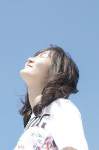 Side view of young woman against clear sky