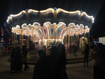 Group of people in amusement park at night