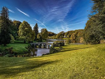 Arch bridge over river against sky
