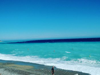 Scenic view of beach against clear blue sky