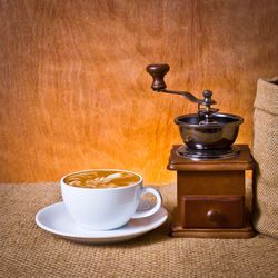 Close-up of coffee by grinder on table