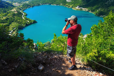 Full length of man photographing in lake