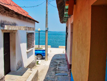 Buildings by sea against sky