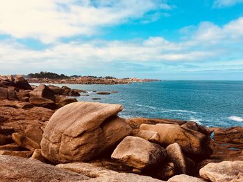 Rocks by sea against sky