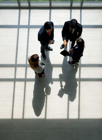 High angle view of business people having discussion while standing on floor