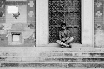 Portrait of a young man sitting on staircase