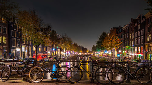 Bicycles parked on street in city at night