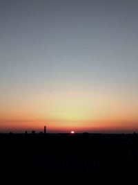 Silhouette buildings against sky during sunset