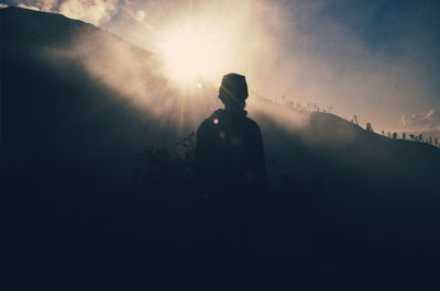 Rear view of silhouette man standing against sky