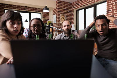 Man with friends looking at laptop screen