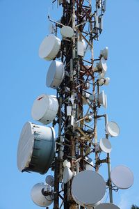 Low angle view of communications tower against clear blue sky