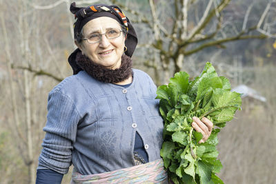 Portrait of smiling senior woman holding vegetable