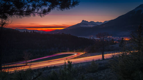 Light trails on road against sky at night